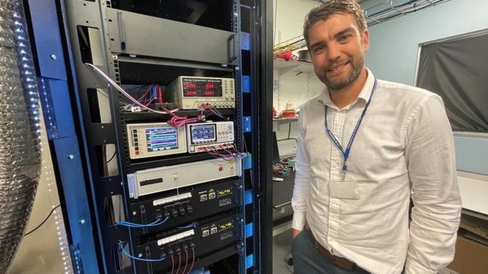 Richard Murray beside photonic quantum computing equipment during a BBC visit